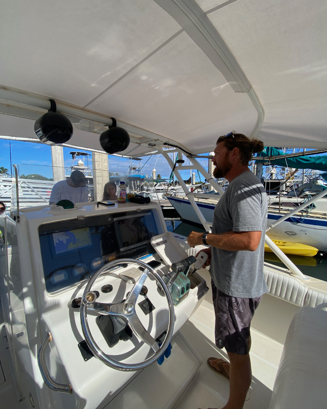 shark dive captain standing at steering wheel of large boat in haleiwa harbor