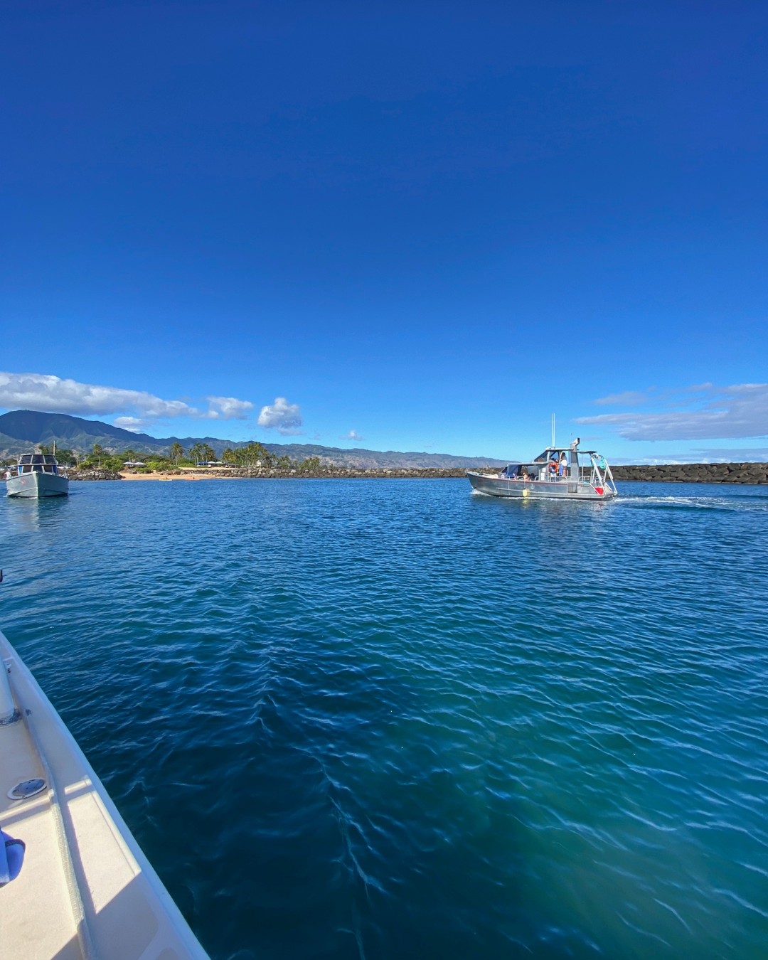 a large blue ocean surrounded by mountains in haleiwa on oahu island