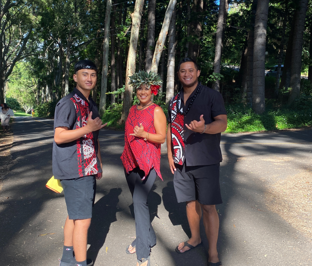 three of the wonderful tour guides at the experience nutridge luau event are dressed in black and red hawaiian attire on tantalus, oahu